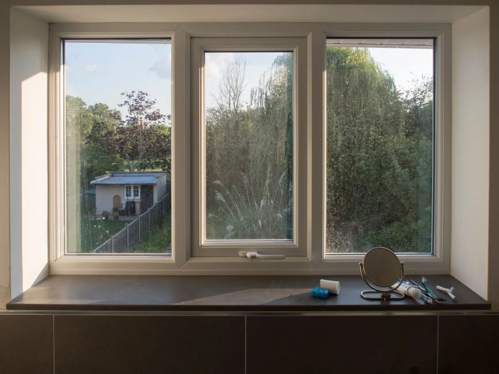 A converted room with a new triple window and deep window seat looking onto the garden