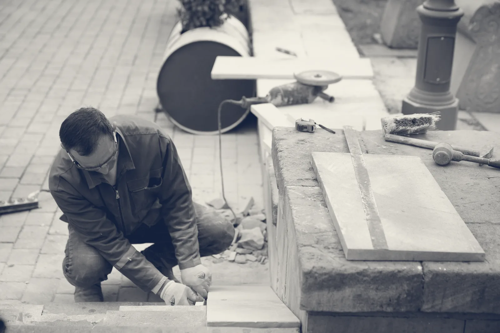 A mason cutting and setting stone facework by hand