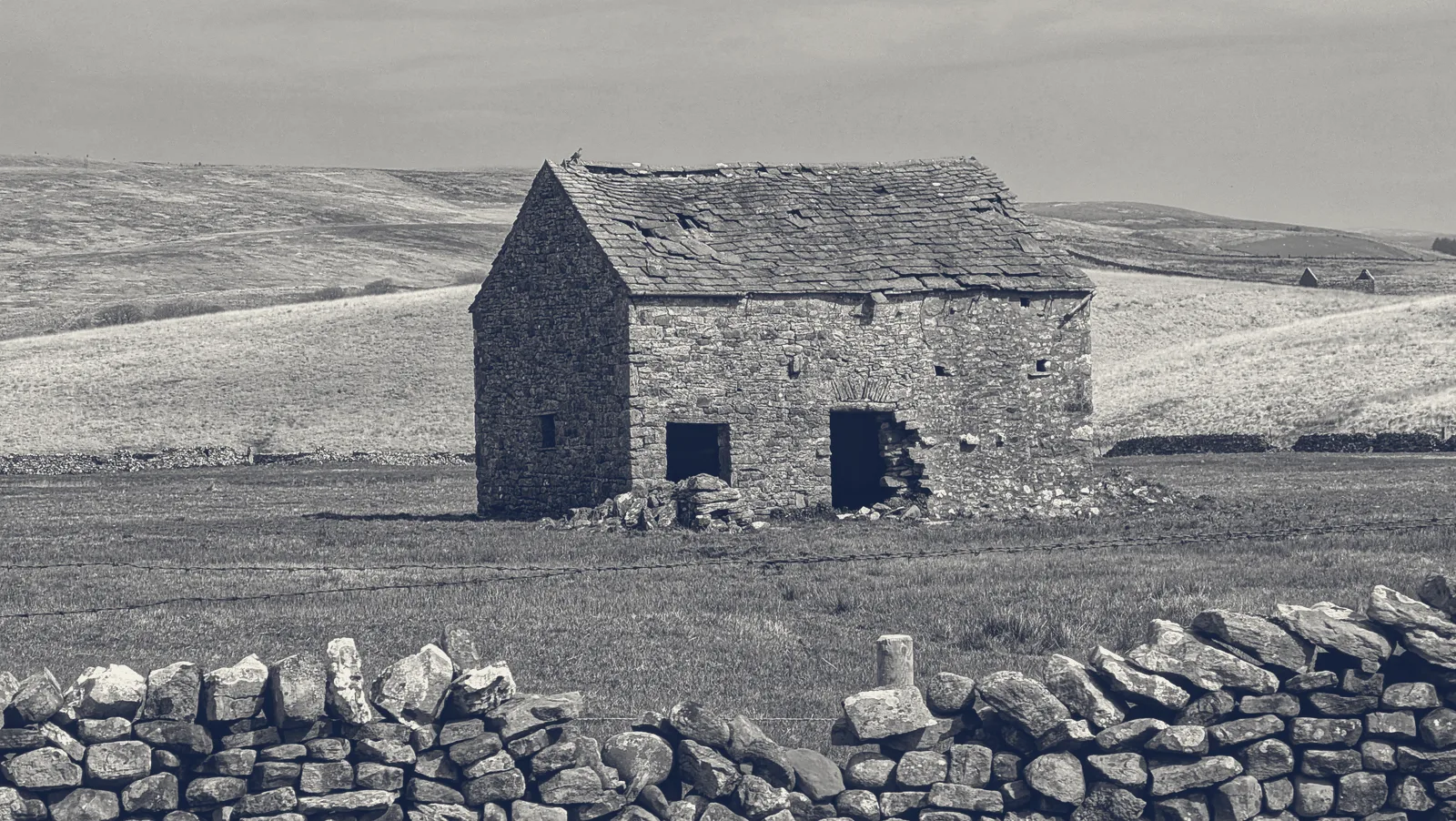 A converted stone barn with new openings and a slate roof